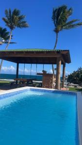 una gran piscina azul con palmeras y el océano en Aquamar Oceanfront Suite, 
