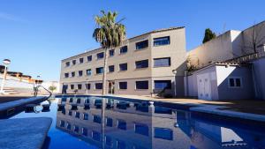 un edificio y una piscina frente a un edificio en CASA SUERTE, en Sant Jaume d'Enveja