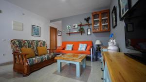 sala de estar con sofá naranja y mesa en CASA SUERTE, en Sant Jaume d'Enveja