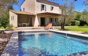 a swimming pool in front of a house at Le Roman Bleu in Paradou