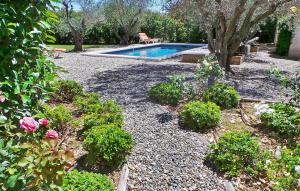 a garden with a swimming pool and some plants at Le Roman Bleu in Paradou