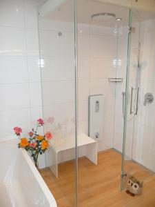 baño con ducha y jarrón de flores en NEU! Ferienwohnung mit Dampfdusche, en Wertach