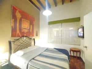 1 dormitorio con 1 cama y TV en Hospedaje Boutique Albergue Verde, en Lima