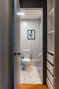 a bathroom with a white toilet in a room at Dpto Recién Remodelado y con Patio (Lastarria) in Santiago