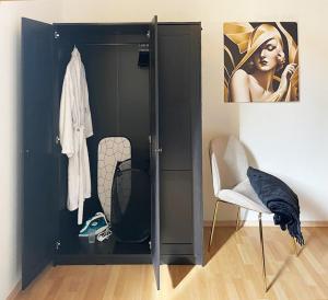 um armário preto num quarto com uma cadeira em NEU! Art Deco Design-Luxus-Apartment, am Markt, Garten em Gera