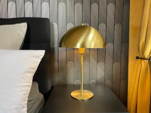 ゲーラにあるNEU! Art Deco Design-Luxus-Apartment, am Markt, Gartenのベッド横のテーブルに座る金灯