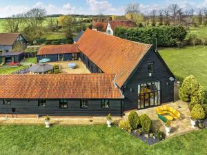 an aerial view of a black house with an orange roof at Doves Barn in Needham Market