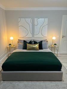 ein Schlafzimmer mit einem großen grünen Bett mit zwei Tischen in der Unterkunft Apartment Hartenrod in Bad Endbach