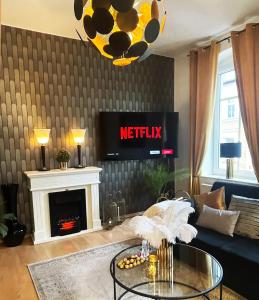 uma sala de estar com um sofá e uma lareira em NEU! Art Deco Design-Luxus-Apartment, am Markt, Garten em Gera