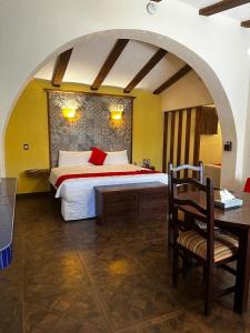 a bedroom with a bed and a desk with a chair at Hotel Medrano Temáticas and Business Rooms Aguascalientes in Aguascalientes