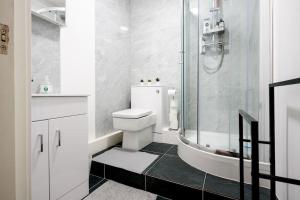 a white bathroom with a toilet and a shower at Charming & Relaxing ~ Walk to Tube ~ 2BRs&2Bths in London