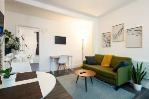 a living room with a green couch and a table at Charming & Relaxing ~ Walk to Tube ~ 2BRs&2Bths in London