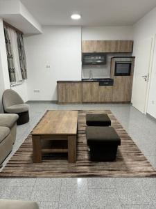 a living room with a coffee table and a kitchen at Lux apartment Bijeljina in Bijeljina