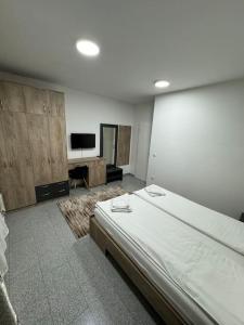 a bedroom with a large bed and a flat screen tv at Lux apartment Bijeljina in Bijeljina