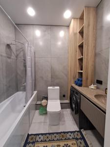 La salle de bains est pourvue de toilettes, d'une baignoire et d'un lavabo. dans l'établissement INJU Arena 1-rooms apartments, à Astana