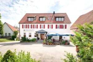 un gran edificio blanco con techo rojo en Gasthof zum Lamm en Gomadingen