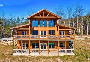 a large wooden house with a large deck at Shell Mtn Splash: 4BR Haven, Views, Pool & Hot Tub in Sevierville