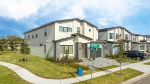 a white house with a car parked in front of it at 6163 Fantastic Home with 12BD in Orlando