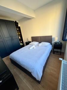 um quarto com uma cama grande e lençóis brancos em Le Secret de l'Architecte : proche Centre et Gare em Dijon