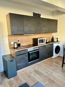 uma cozinha com um fogão e um micro-ondas em Le Secret de l'Architecte : proche Centre et Gare em Dijon