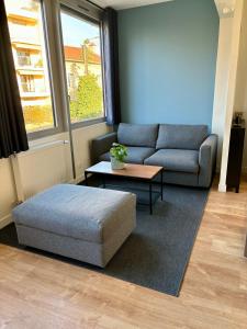 uma sala de estar com um sofá e uma mesa de centro em Le Secret de l'Architecte : proche Centre et Gare em Dijon