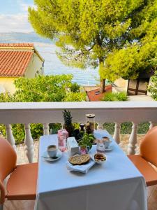una mesa con comida y bebida en el balcón en Villa Marina Čiovo Trogir, en Trogir