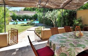 a table and chairs on a patio with a view of a pool at Zèbre in Eyragues +18 photos