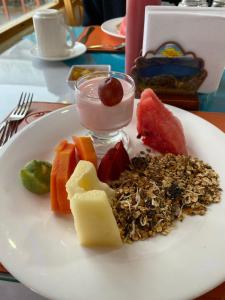 a plate of food with cheese and fruit on a table at Hostería Chukirawa in Quilotoa