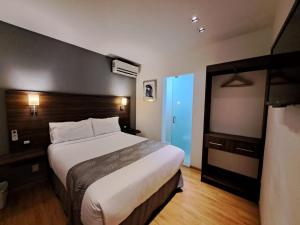 um quarto com uma cama grande num quarto de hotel em El Hotel Business Class - Zamora Centro em Zamora de Hidalgo