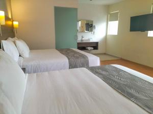 a hotel room with two beds and a tv at El Hotel Business Class - Zamora Centro in Zamora de Hidalgo