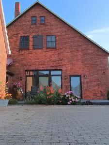 a brick building with windows and flowers in front of it at Sloop fein in Kransburg