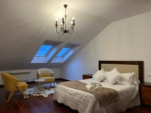 1 dormitorio con cama y lámpara de araña en Dúplex Pico Sacro en Lestedo