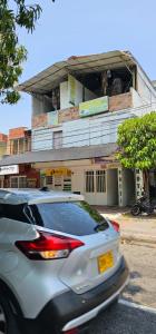 a white car parked in front of a building at Hotel Sol Llanero in Yopal