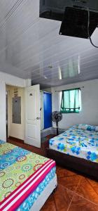 a bedroom with two beds and a tv in it at Hotel Sol Llanero in Yopal