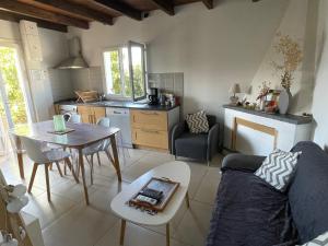 una cucina e un soggiorno con un divano e un tavolo di Maison de charme entre mer et montagne a Forciolo