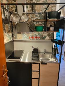 una cocina con fregadero y un ordenador portátil en la encimera en Stanza Lillina en San Benedetto del Tronto