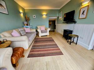 a living room with a couch and a flat screen tv at Talarfor Barmouth in Barmouth