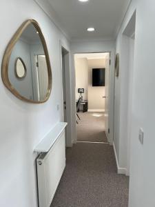 a white bathroom with a mirror and a hallway at Glenshellach Apartment Oban in Oban