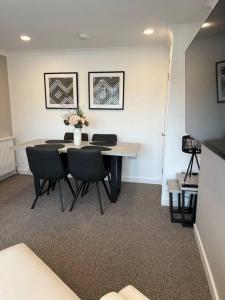 a room with a table with chairs and flowers on it at Glenshellach Apartment Oban in Oban