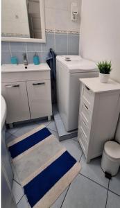 een badkamer met een witte wastafel, een toilet en een wastafel bij Esztergom apartman in Esztergom