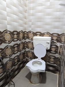 a bathroom with a white toilet in a room at Hotel Shikhar Inn in Ujjain