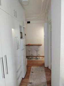 a kitchen with white cabinets and a wooden floor at Átutazó Apartman in Nyíregyháza