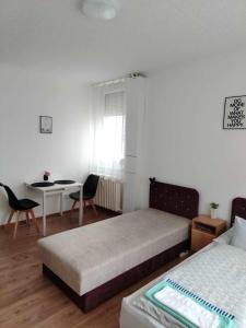 a bedroom with two beds and a table and chairs at Átutazó Apartman in Nyíregyháza