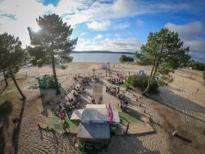 a group of people sitting on a beach at Mobilhome N°222 : 3ch / 2sdb dans camping 4* in Gastes