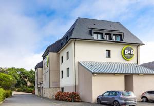 un edificio con un segnale BBQ sopra di B&B HOTEL Saint Malo Sud a Saint-Jouan-des-Guérets