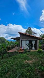 una pequeña casa en la parte superior de un exuberante campo verde en Casa Sedna Andes, en Los Andes