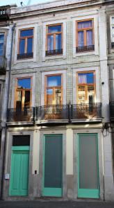 een gebouw met groene deuren en ramen aan een straat bij Loulé Estúdios in Porto