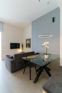 a living room with a glass table and a couch at TWINSTAY in Catania