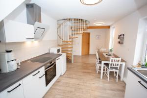 eine Küche und ein Esszimmer mit einem Tisch und einer Treppe in der Unterkunft Ferienwohnung Zschopau Zentrum in Zschopau