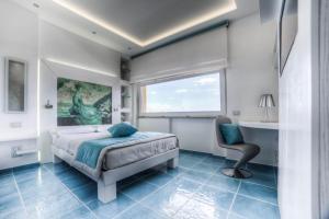 a bedroom with a bed and a desk and a window at La Madegra Seasuite in Salerno +133 photos